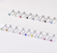 Two horizontal rows of silver-toned labret piercings with faceted gemstone backings in assorted colors, arranged on a clean white background.