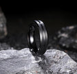 Black ring with a reflective surface on a dark stone background