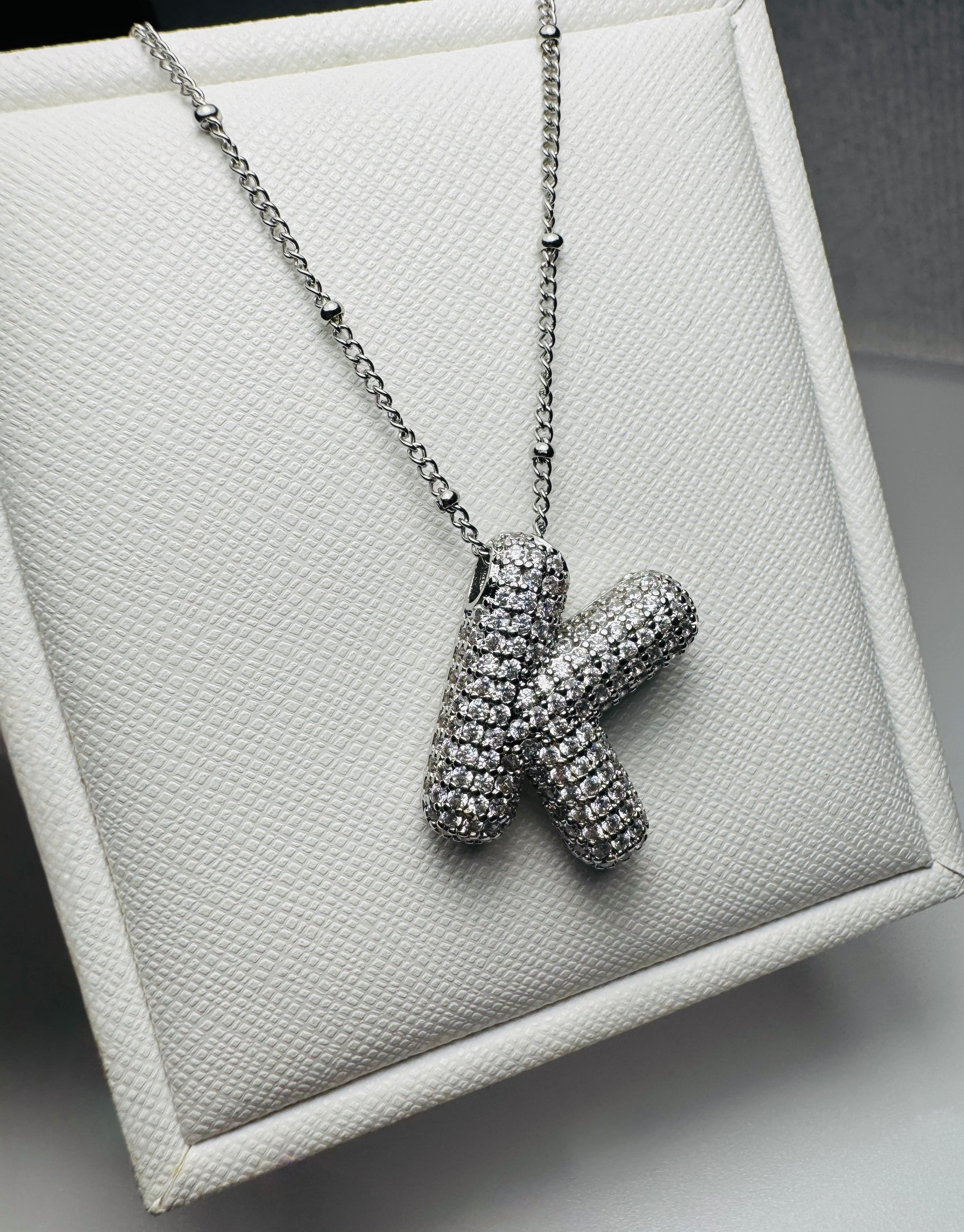 Silver necklace with a unique pendant on a textured surface