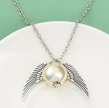 Necklace with a pendant featuring wings on a white plate against a green background