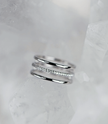 Silver ring with small stones on a light gray background
